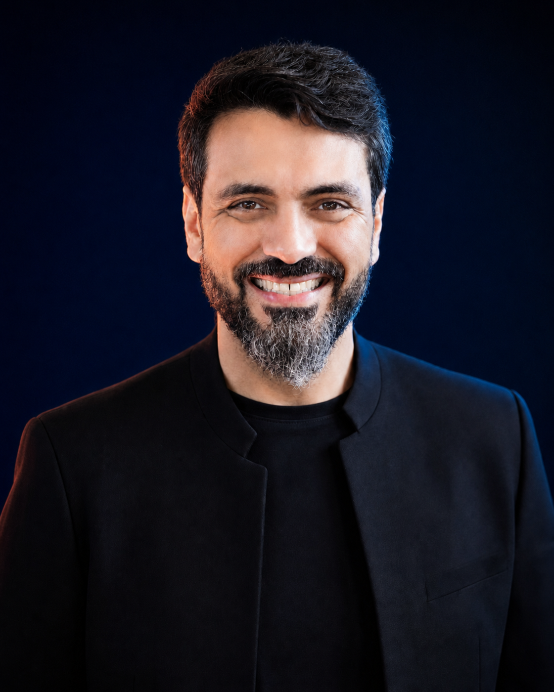 Retrato editorial de Wellington Dias, sorrindo, com cabelo escuro cuidadosamente penteado e barba aparada, sobre fundo navy.